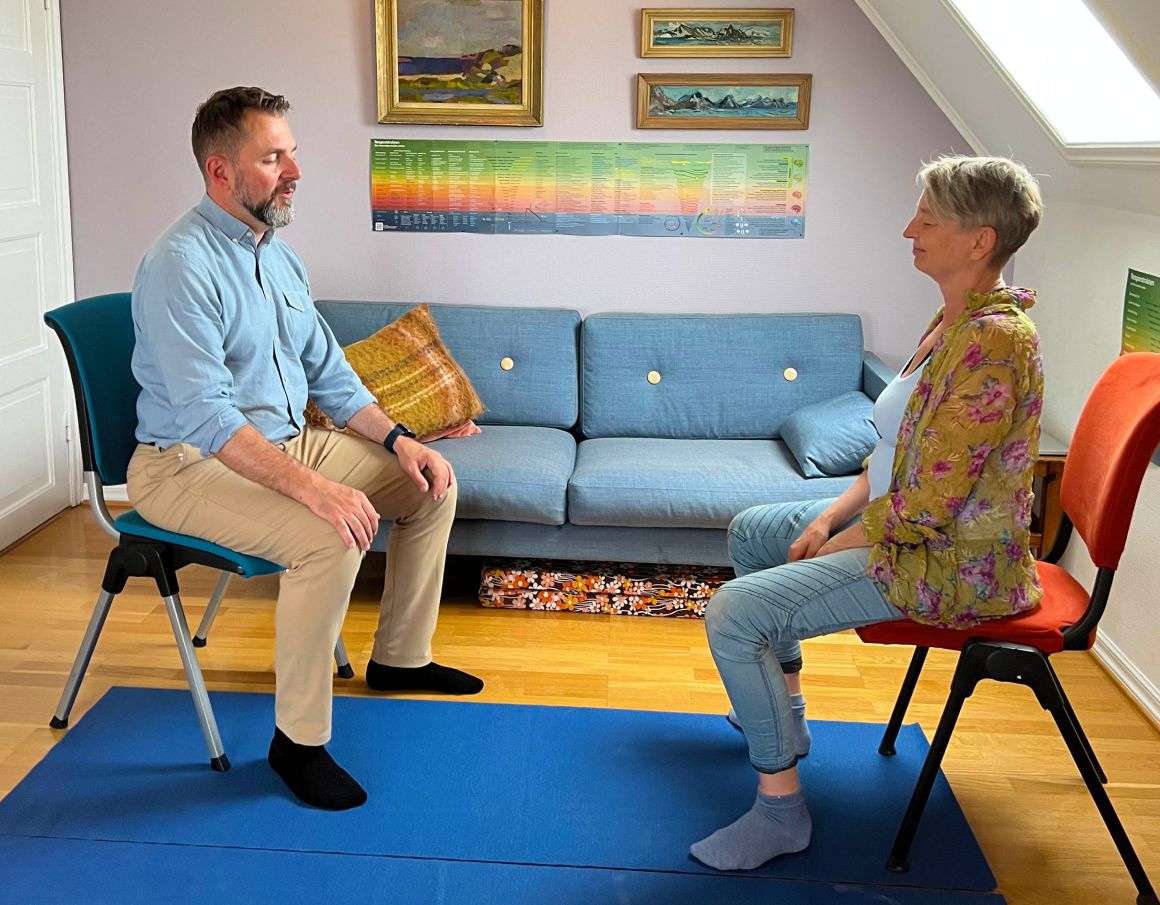 Experience Kroppsorientert Traumeterapi with Hans Holter Solhjell as he guides a patient through breathing exercises. Enhance your mental well-being and capacity development with expert therapy.